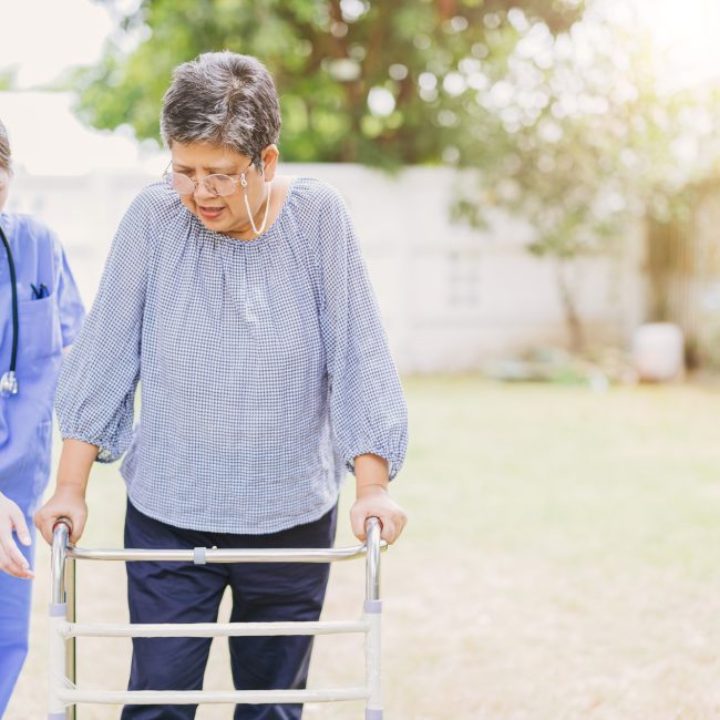 senior elderly adult woman with disability using walker walk practice in home care nurse doctor